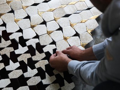 Artisan laying tiles in geometric pattern