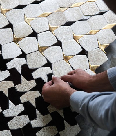 Artisan laying tiles in geometric pattern