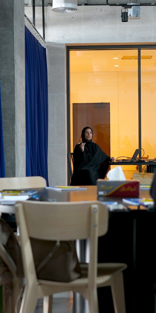 woman explaining to a group of people on a table