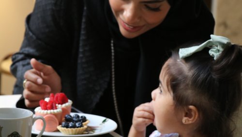 A woman and a young daughter enjoying desserts