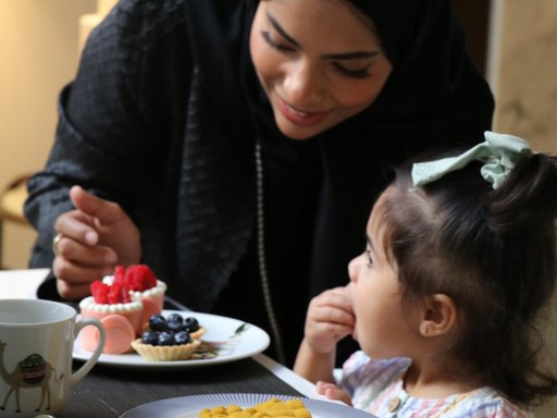 A woman and a young daughter enjoying desserts