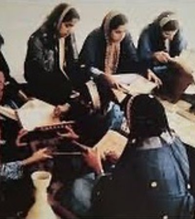 صورة قديمة تظهر فيها آمنة محمود الجيدة تُدرّس مجموعة من الطالبات.