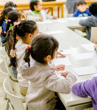 Children listening to their teacher talk in a classroom