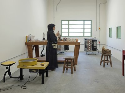 Interior view of clay lab with equipment and a woman standing.