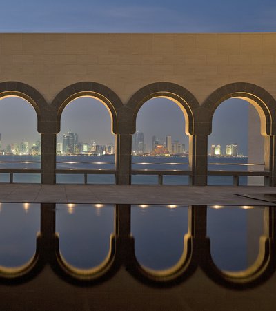 Nighttime view of Doha from the Museum of Islamic Art looking through a wall of arches