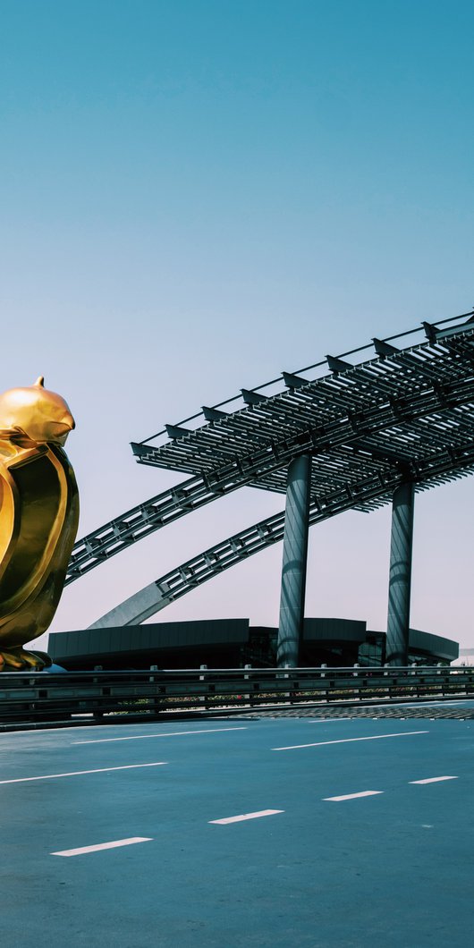 Bright gold-coloured sculpted falcon on the side of the road leading to Hamad International Airport