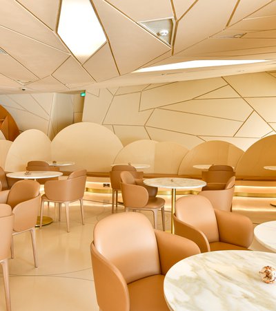 View of the interior of the Desert Rose cafe showing tables and chairs and the faceted shapes of the NMoQ building