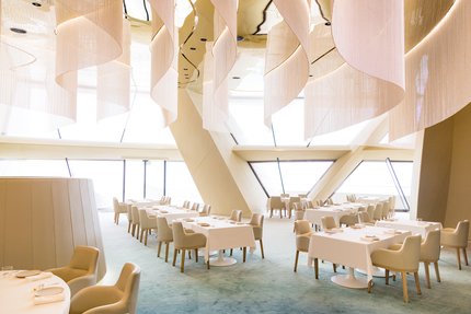 منظر داخلي لمطعم جيوان في متحف قطر الوطني، يُظهر ترتيب الطاولات والعمارة الداخلية