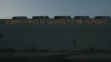 Martin Creed's neon lettering spelling out "Everything is Going to be Alright" installed outside the Al Riwaq gallery