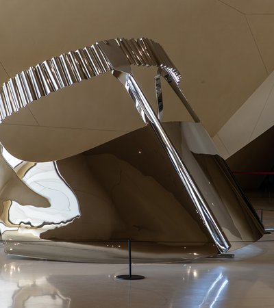 Large-scale shiny silver metallic sculpture depicting a 'niqab', a traditional face covering