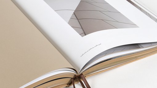 Open page book displaying a close up shot of the National Museum of Qatar exterior geometric patterns