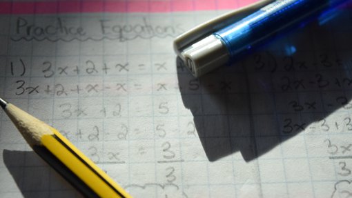 A picture of two pens on a page with math problems written on it