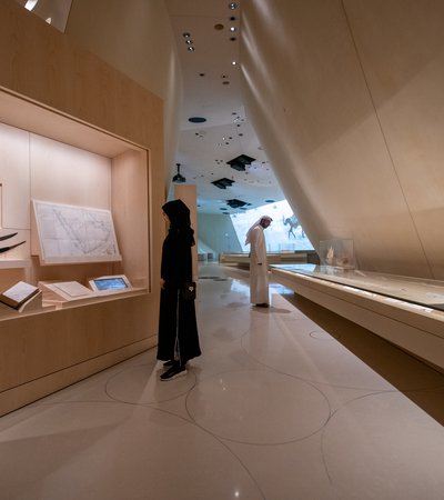 A man and a woman observing the gallery space at the National Museum of Qatar