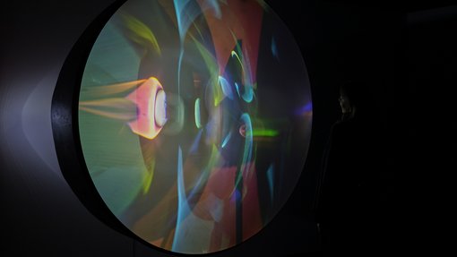 A circular projection screen displaying colourful lights.