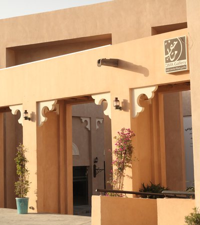 A medium shot showing the arches and traditional clay walls of the gallery's facade